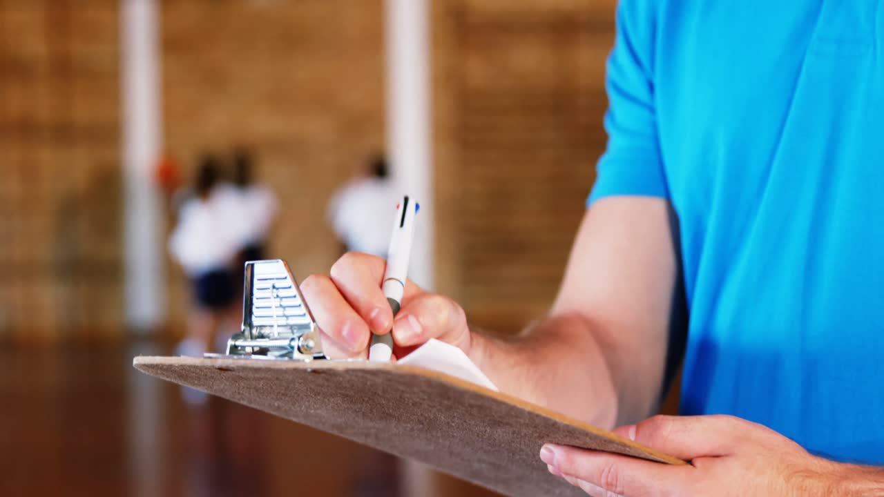 maestro de deportes escribiendo en el clipboard