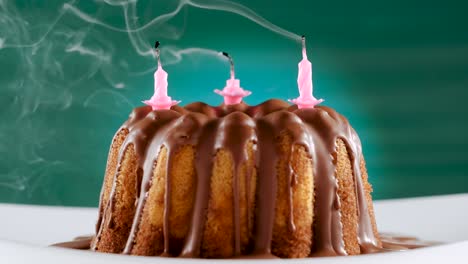 blowing out pink birthday candles on marble cake with chocolate nougat icing