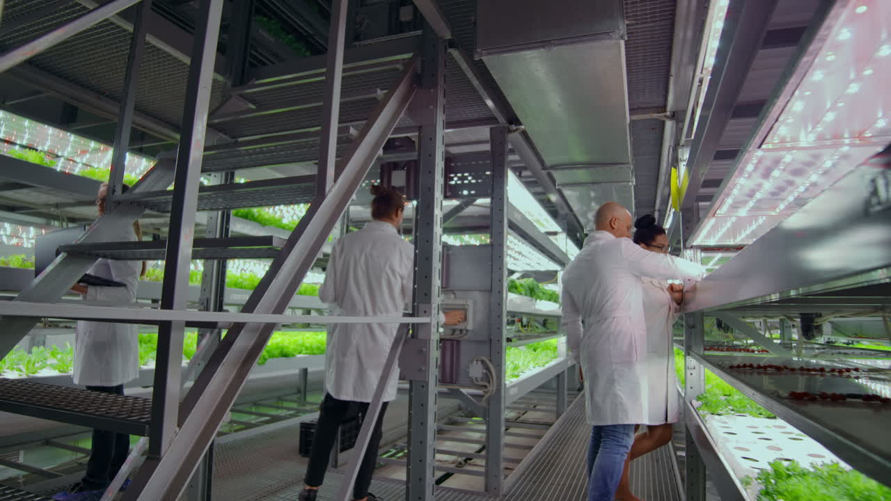 los científicos y los agricultores trabajan juntos en un equipo para crear plantas limpias en un entorno artificial utilizando computadoras portátiles y tabletas de tecnología moderna.