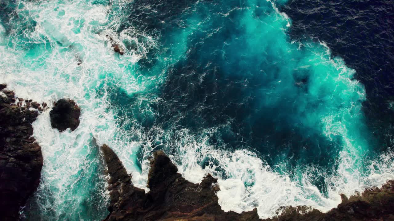 Aerial View of Powerful Ocean Waves Crashing on Rocky Coastline