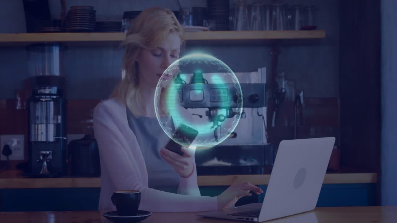 Kvinde ved cafedisk, rækker ud efter telefon, mens en holo-kugle dukker op, skriver på bærbar computer, der synkroniserer teknologi.