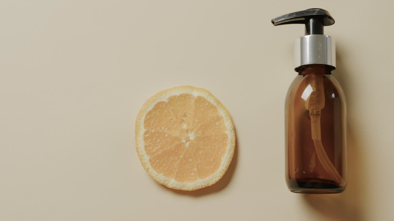 베이지색 배경에 프, 레몬 조각 및 복사 공간과 함께 유리 병의 근접