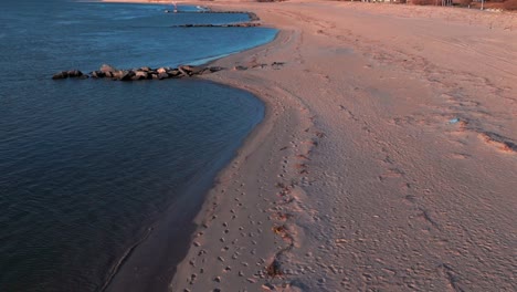 Una-Vista-De-ángulo-Bajo-De-La-Playa-Vacía-En-El-Canal-Reynolds-En-Atlantic-Beach,-Nueva-York-Durante-El-Amanecer.