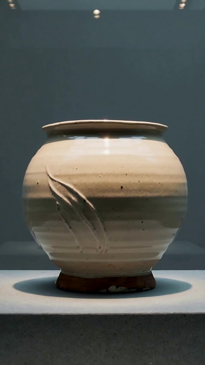 Video verticale: Un vaso che ruota su un piedistallo mentre inizia a girare e le luci riflettono un motivo a foglia in mostra.