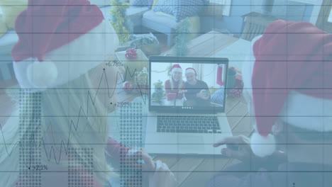 animation of financial data processing over diverse friends in santa hats using laptop at christmas