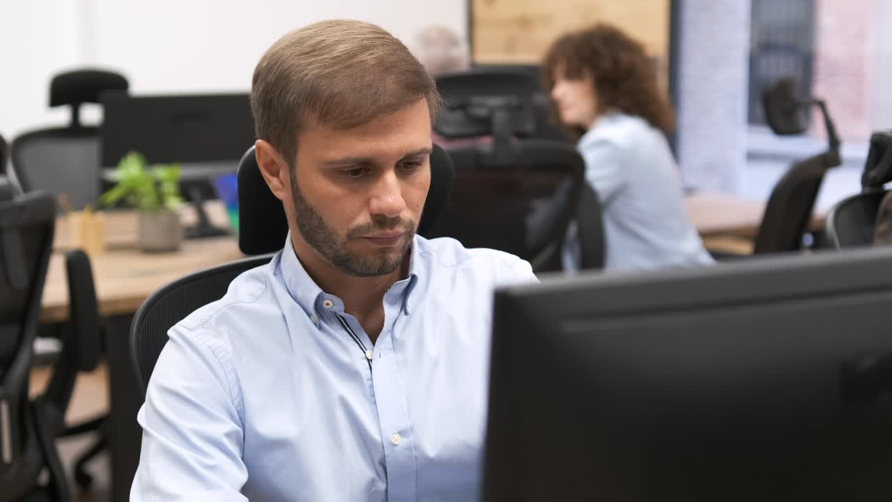 Focused businessman using desktop PC in creative office