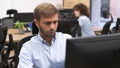 focused businessman using desktop pc in creative office