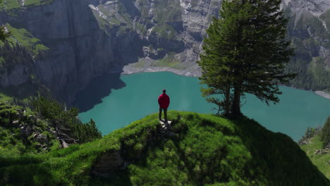 view behind male hiker overlooking oeschinen lake in bernese oberland, switzerland