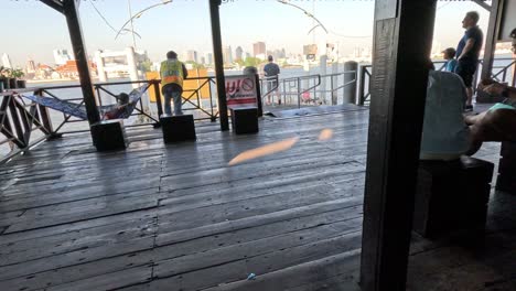 progression from a riverside cafe to boarding a ferry