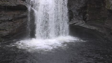 slow motion shot of the falls of falloch splashing onto the water below
