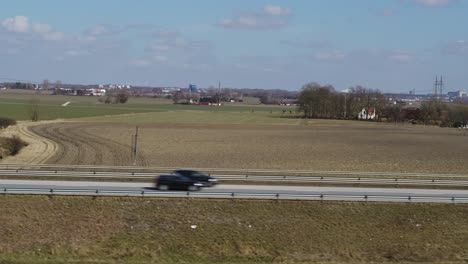 drones fly next to a freeway with traffic in spring