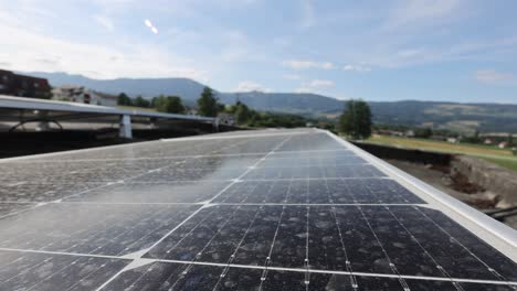 Dolly-Forward-over-solar-panel-on-rooftop-of-building-in-wilderness-during-sunny-day,-close-up