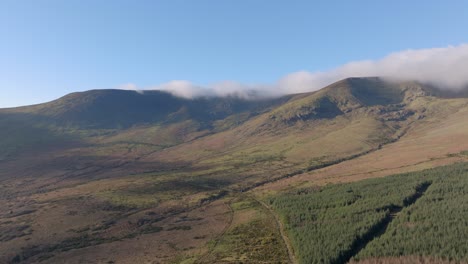 Drone-landscape-mountainside-with-low-clouds-blue-Skys-in-winter-Comeragh-Mountains-Waterford-Ireland