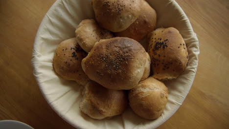 top shot of self-made freshly baked breakfast rolls buns on the breakfast table in a bread basket on a relaxed weekend morning