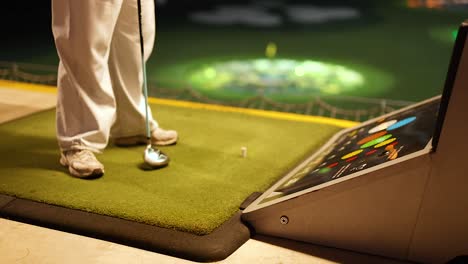 person playing golf indoor simulator at night