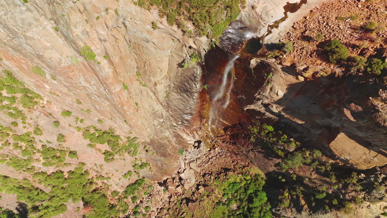 Tiny creek falling from steep cliff in Yosemite National Park, California, USA. Almost dried waterfall from aerial view on sunny hot day.