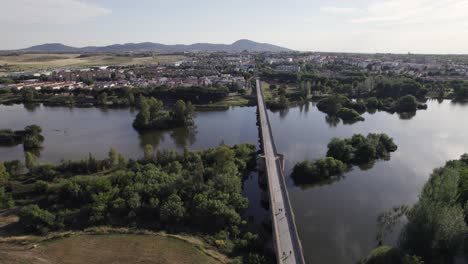 Antique-bridge,-Puente-Romano-in-Merida,-roman-landmark,-aerial-orbit-summer-day