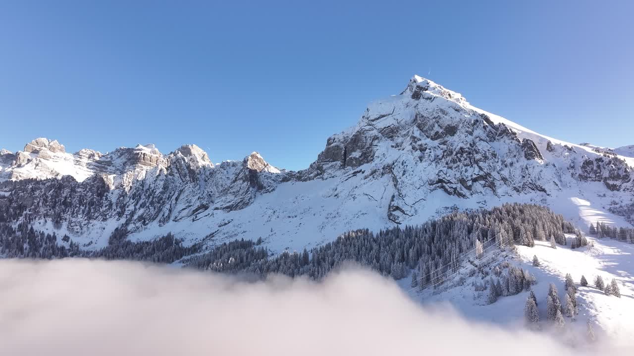 Aerial - Fronalpstock, Glarus, Switzerland, with snowy peaks and clear blue skies