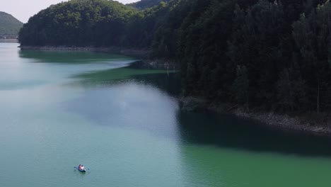 revealing shot of paltinu lake of doftana valley in romania showing the beauty of the nature with trees meeting the lake