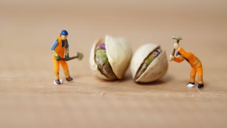 miniature workers working with pistachio nuts