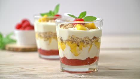 mango fresco casero y frambuesa fresca con yogur y granola - estilo de comida saludable