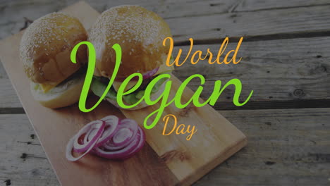 animation of world vegan day text in orange and green over vegetarian burgers and red onion