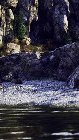 rocky shoreline with calm water reflecting sunlight during daytime