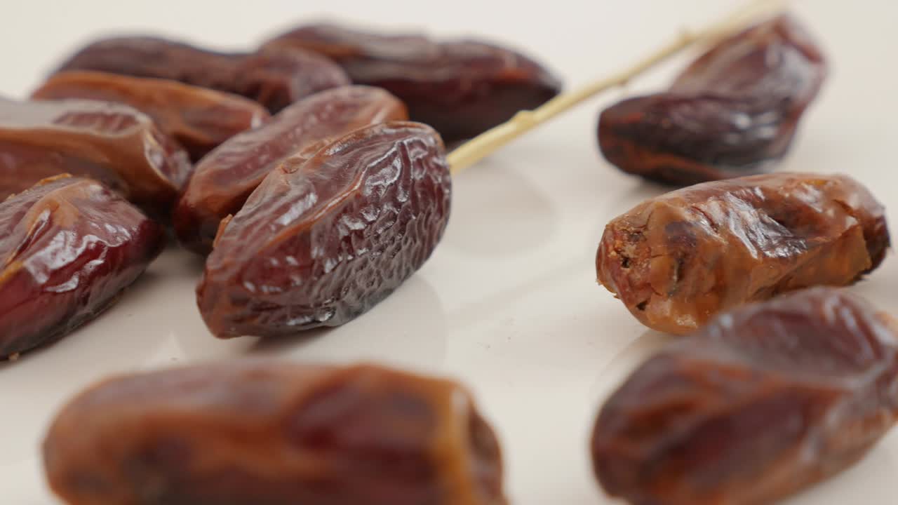 Palm dates exotic eastern fruit on white background slow tilting 4K