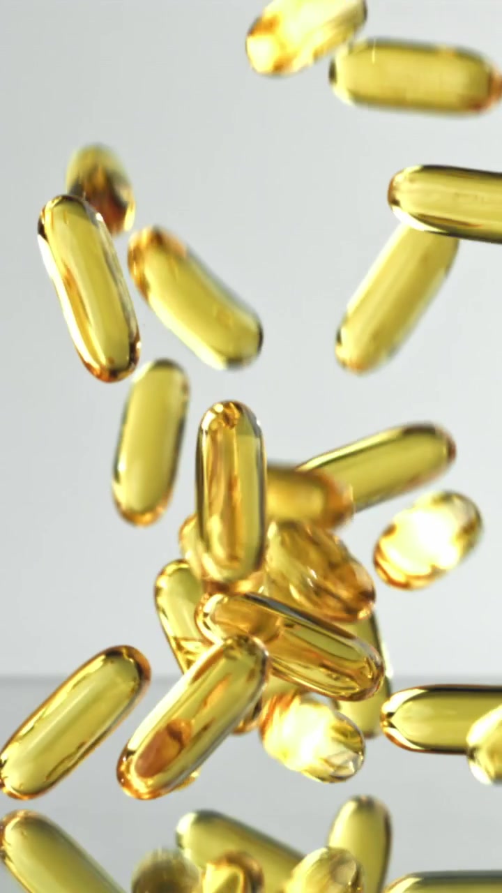 Capsule softgel dorate di Omega-3 che cadono al rallentatore.