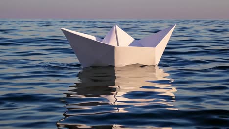 delicate white origami boat gently floating across dark blue ocean, creating soft ripples and mirrored reflections beneath expansive serene sky