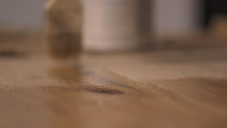 paintbrush applying wood varnish back and forth to diy wooden oak desk at home close up