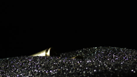 6mm advanced rifle cartridges dropping on heap of gunpowder against black background
