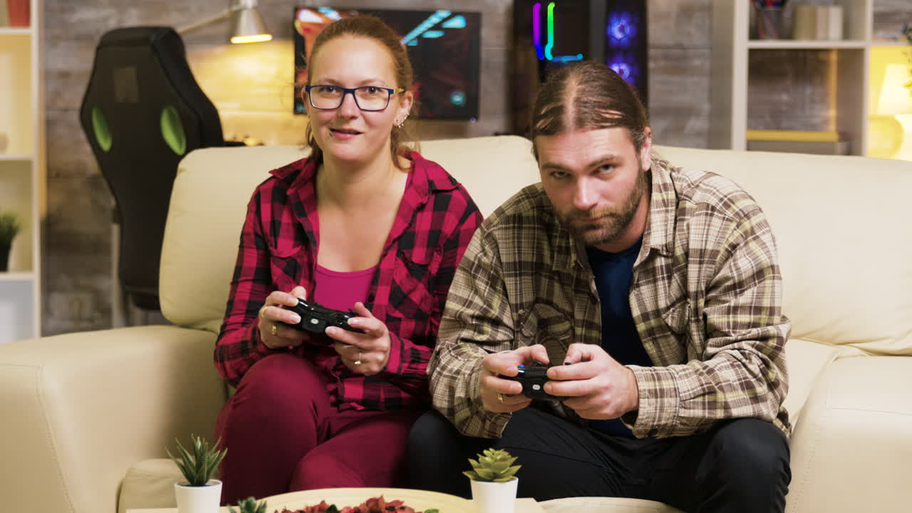 pareja jugando videojuegos en un sofá