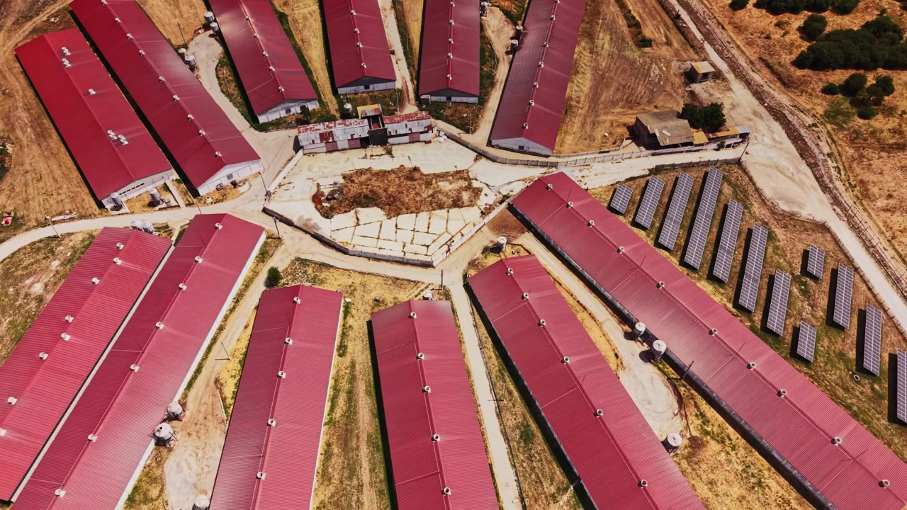 Luftfoto af landbrugsbygninger og siloer i et landområde