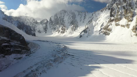 épica toma de un dron giratorio cinematográfico que atraviesa la gran abertura en el glaciar ak-sai en kirguistán