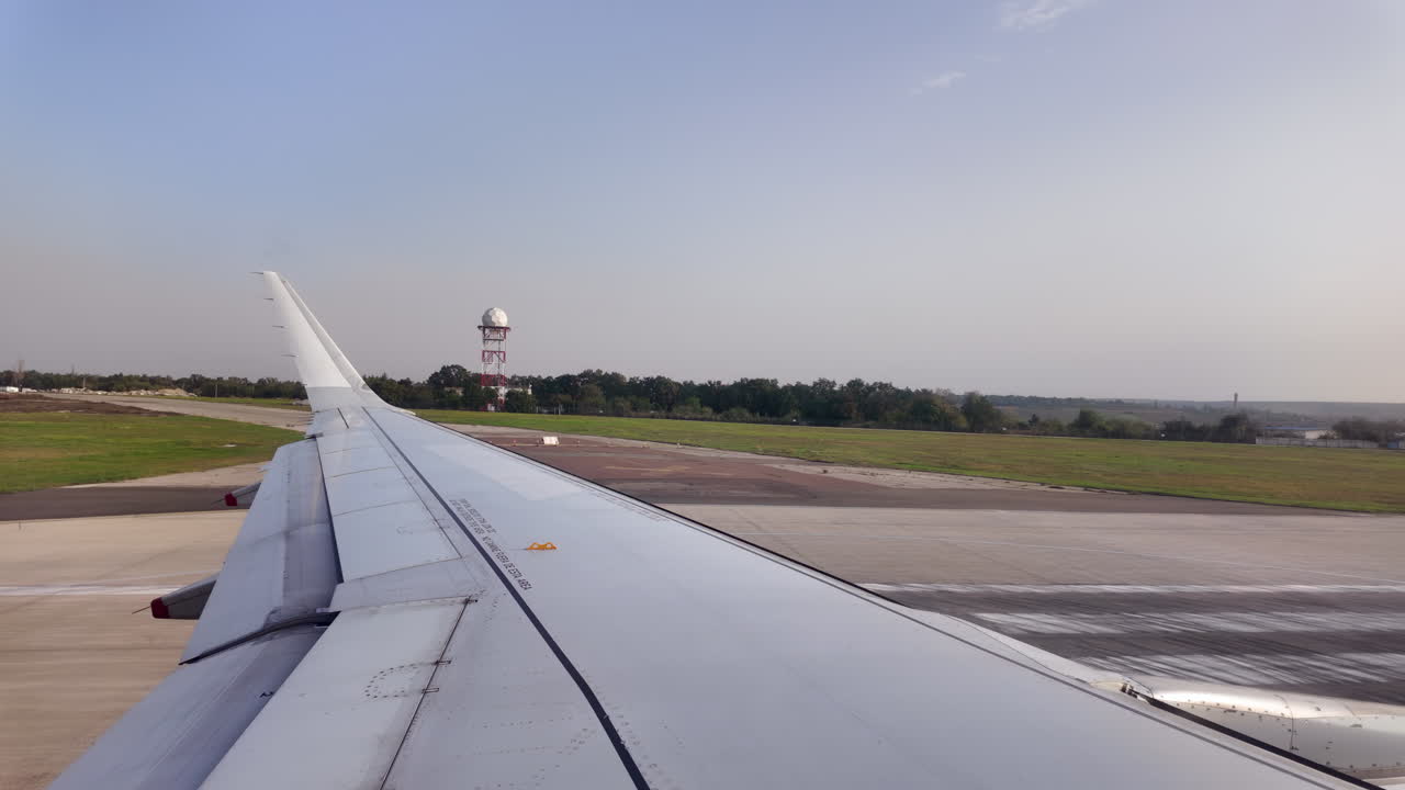 Chisinau, Moldavia - 12 luglio 2025: vista dell'ala dell'aereo dal finestrino che si muove attraverso l'Aeroporto Internazionale di Chisinau