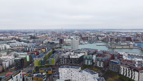 aerial tracking shot over the cityscape of jatkasaari, cloudy day in helsinki