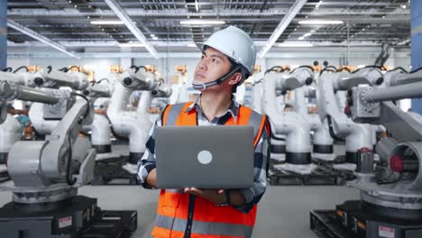 Engineer working with robots in a factory