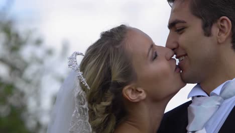 laughing newlyweds kissing outside