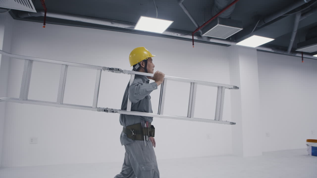 Asian Construction Worker Carrying Ladder