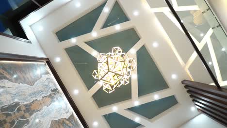 looking up at high hanging square ceiling lights viewed from first floor