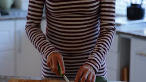 mujer mayor cortando verduras en la cocina 4k