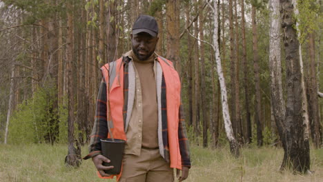 attivista uomo afroamericano che sorride alla macchina fotografica mentre tiene un piccolo albero