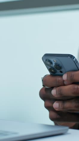 person using smartphone on a laptop