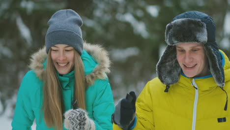 loving man and woman in slow motion in winter skiing in the woods. valentine day