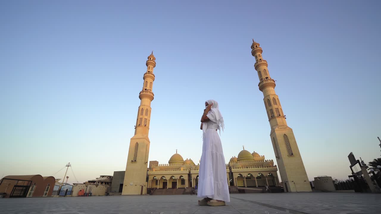 엘 미나 모스크를 방문하는 여성 관광객은 전통적인 히자브와 긴  드레스를 입고 이집트의 후르가다에 있습니다.