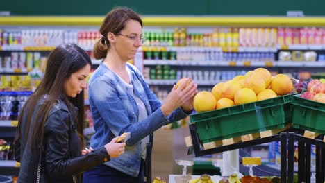 two shoppers engaged in a conversation about fresh produce in a colorful grocery store aisle, highlighting the vibrant selection of fruits and vegetables