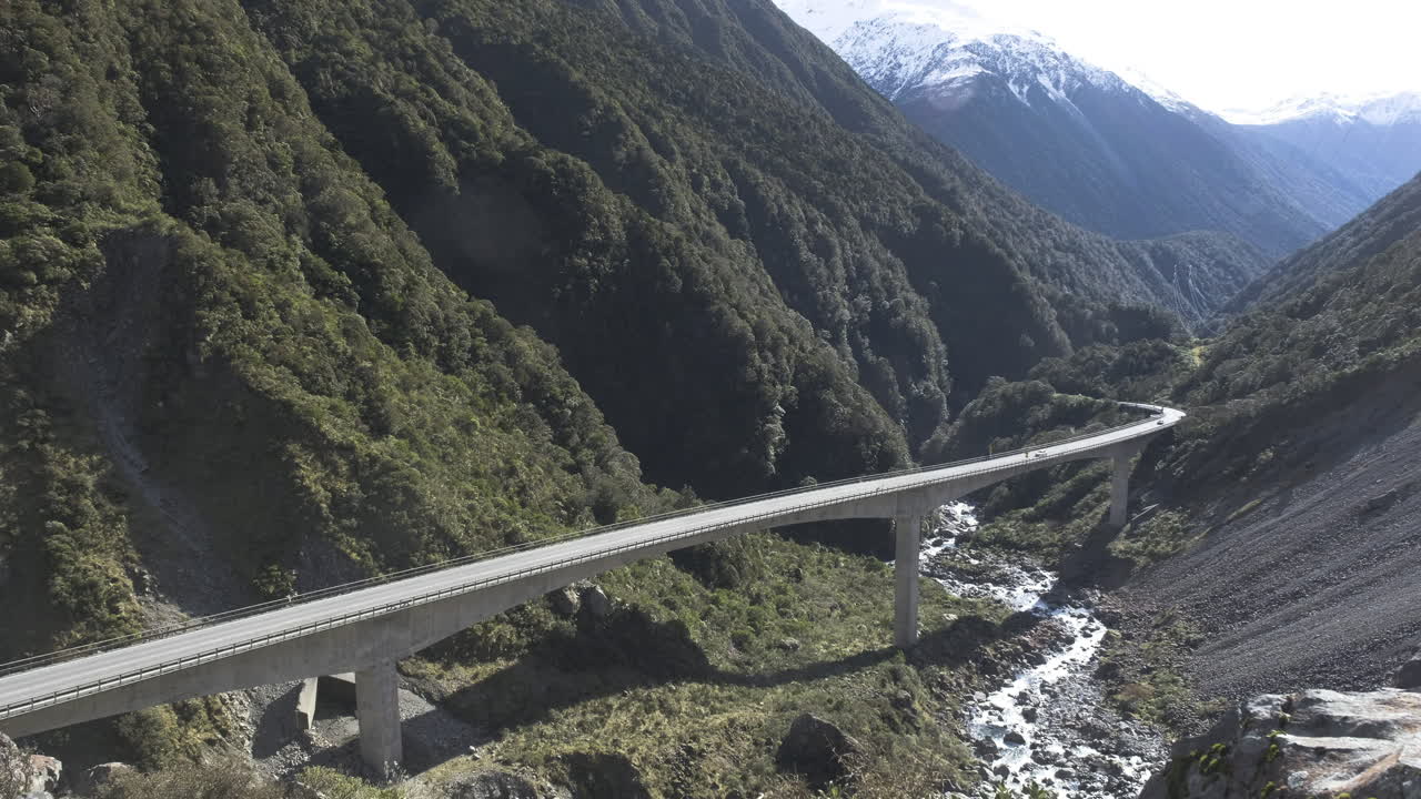 coches circulando por un viaducto en las montañas de nueva zelanda