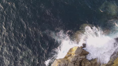 Vista-Aérea-De-Las-Olas-Del-Mar-Rompiendo-En-La-Costa-Rocosa