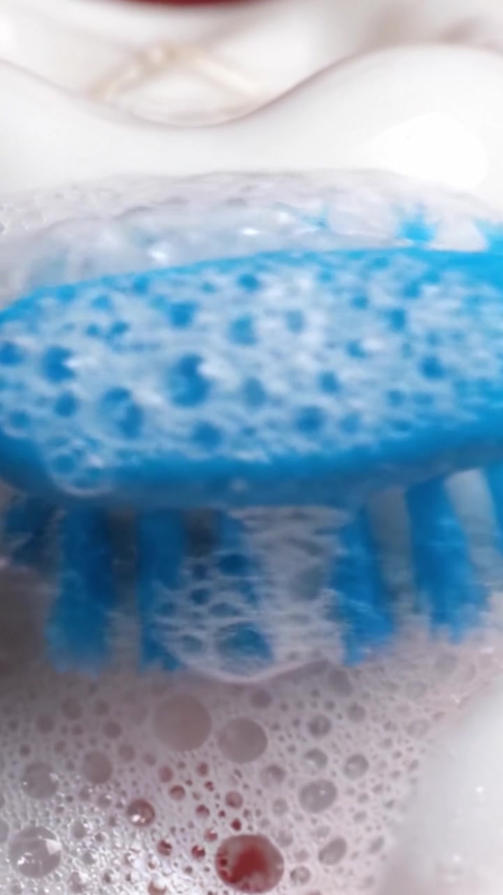 Esame Dettagliato della Superficie di un Dente Durante lo Spazzolamento, Evidenziando l'Azione della Schiuma e dello Spazzolino nelle Pratiche di Igiene Orale